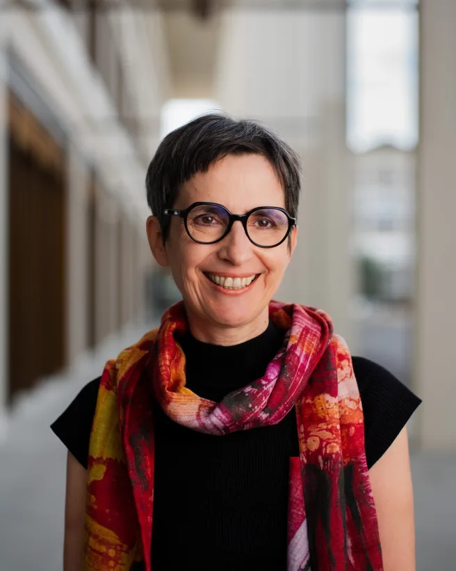 Dr. Annette Kindlimann, lächelnd vor einer Spitalfassade