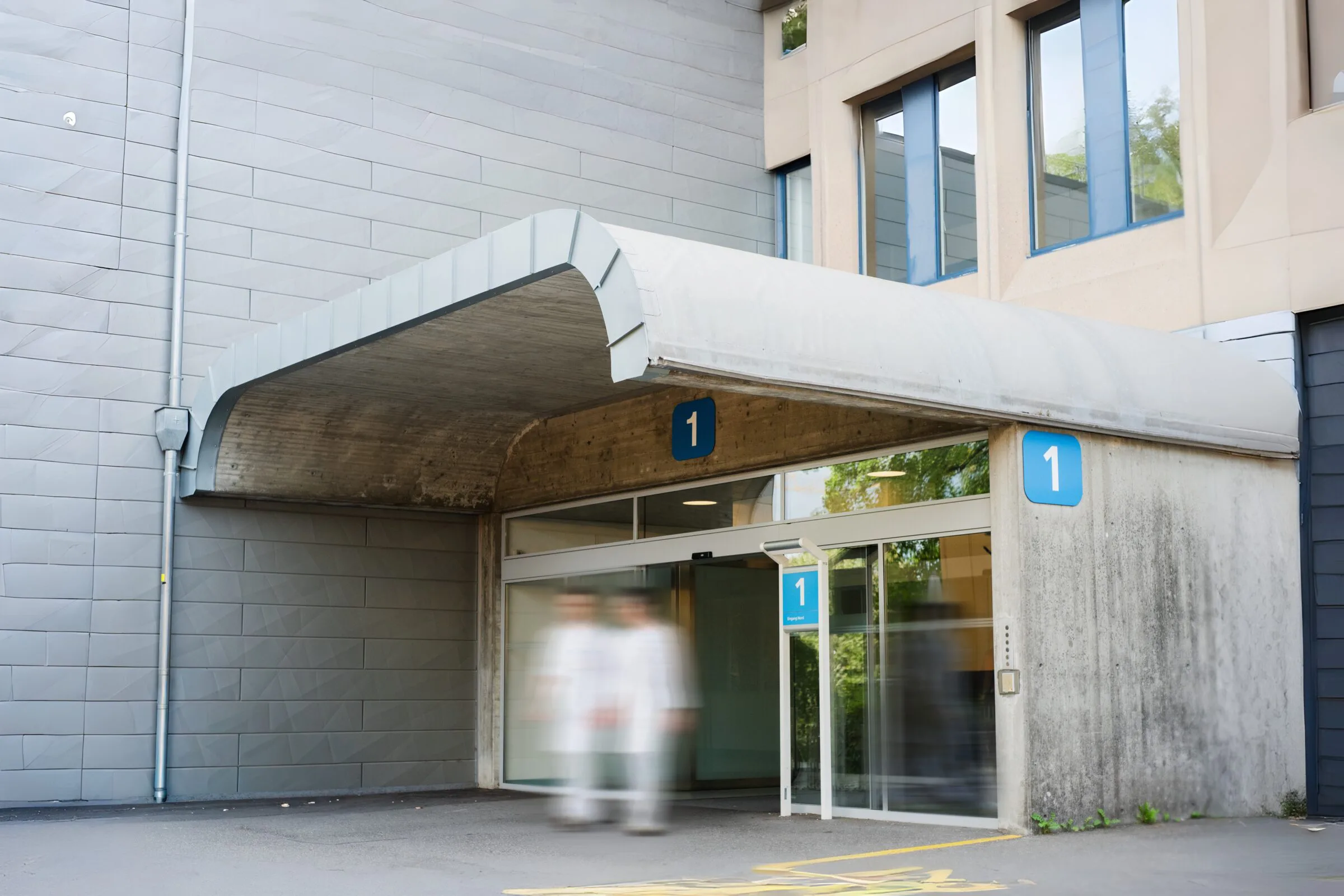 Eingang eines Spitals, Pflegefachpersonen in Bewegung