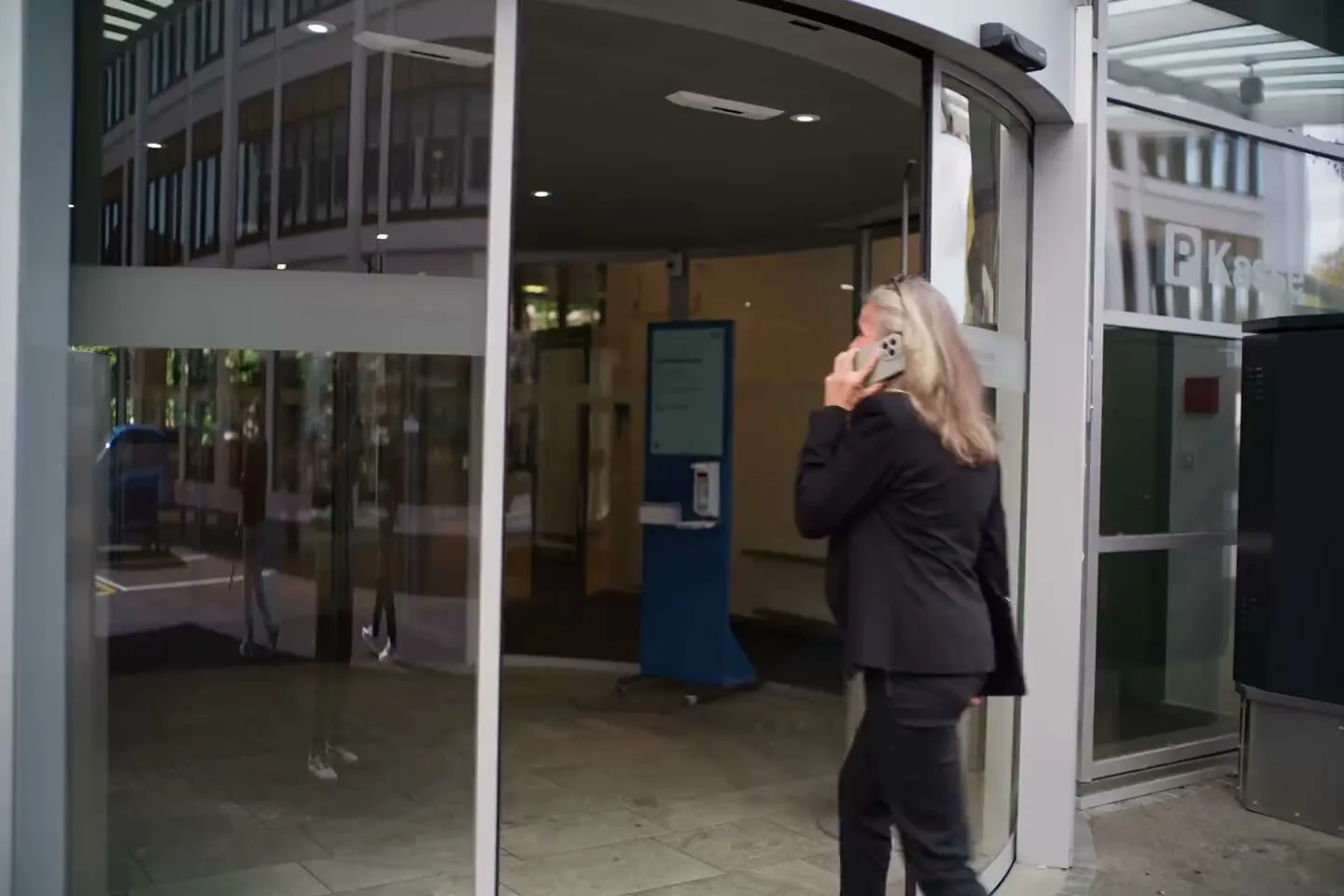 Monika Wiedemeijer telefoniert vor dem Eingang eines Spitals