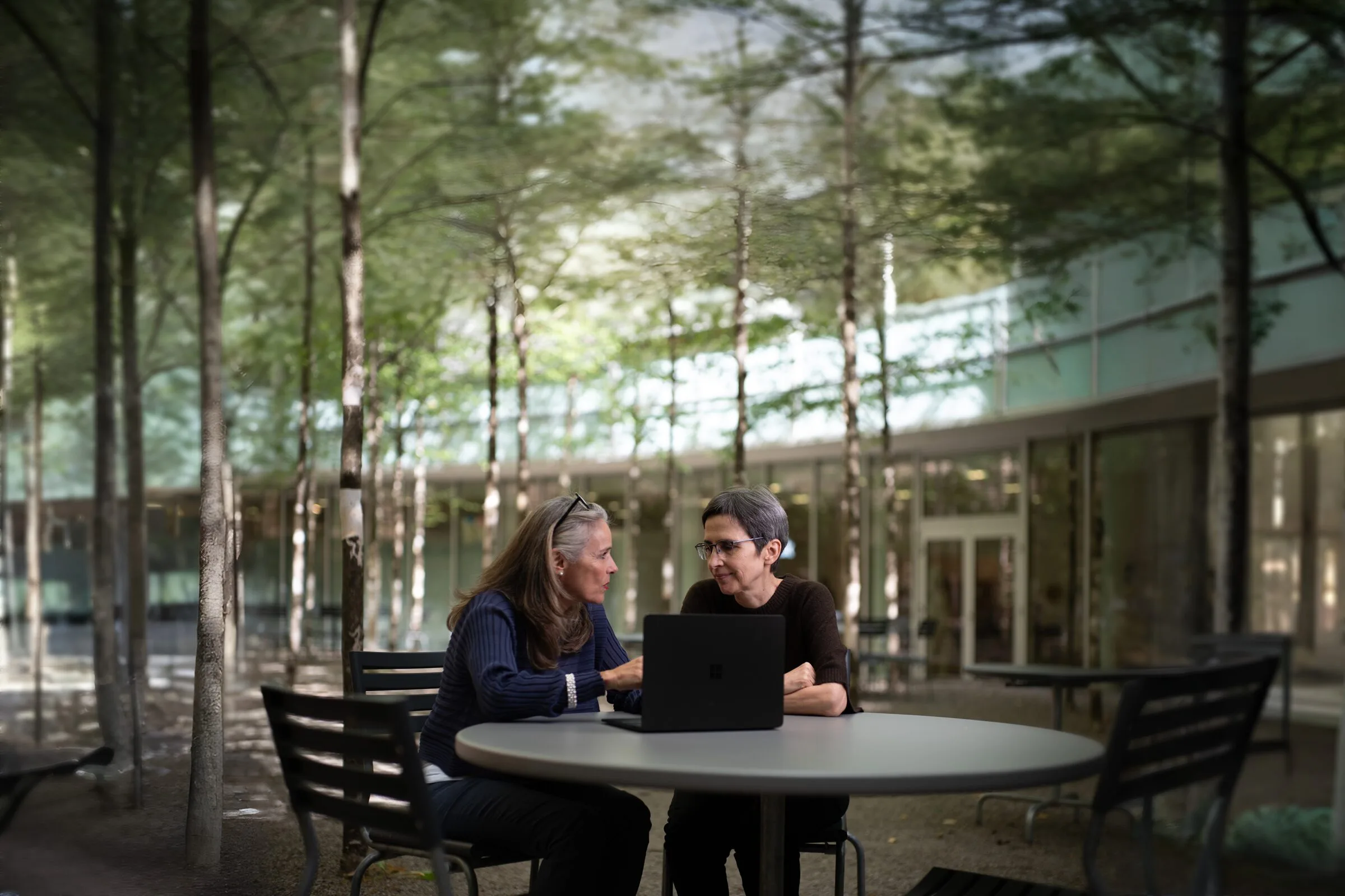 Monika Wiedemeijer und Annette Kindlimann im Gespräch an einem Tisch im Innenhof